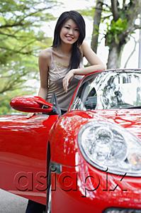 AsiaPix - Woman standing next to red sports car