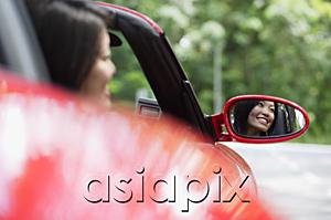 AsiaPix - Woman in red sports car, reflected in side view mirror