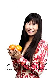 AsiaPix - Woman with long straight hair, holding two oranges
