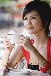AsiaPix - Woman having cup of coffee, looking away