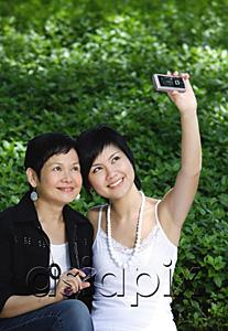 AsiaPix - Women taking a picture with mobile phone