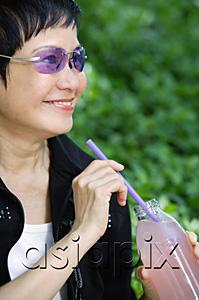 AsiaPix - Woman with bottled drink and straw, looking away