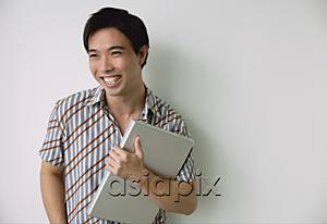 AsiaPix - Man holding laptop, smiling