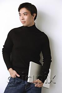 AsiaPix - Man wearing black turtleneck, hand in pocket, holding laptop