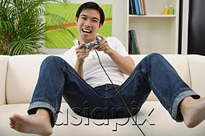 AsiaPix - Man playing with video game at home