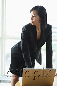 AsiaPix - Businesswoman with laptop, standing, looking away