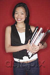 AsiaPix - Woman carrying books, smiling at camera