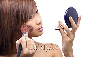 AsiaPix - Teenage girl applying make-up, looking at compact