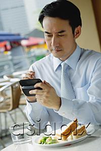 AsiaPix - Businessman in cafe, using PDA