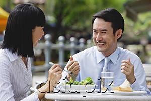 AsiaPix - Businesswoman and businessman at outdoor cafe, having lunch