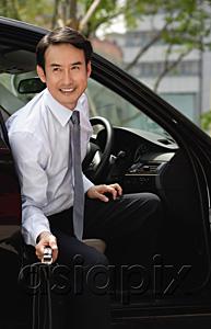 AsiaPix - Businessman getting out of car, smiling