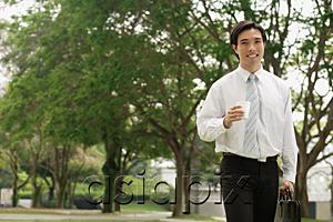 AsiaPix - Businessman carrying briefcase and Styrofoam cup, outdoors