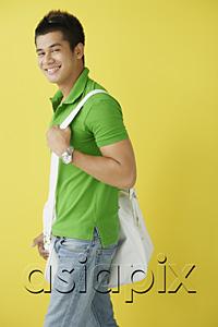 AsiaPix - Man in green polo shirt, standing against yellow background, sunglasses on