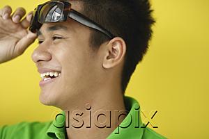 AsiaPix - Man adjusting sunglasses, looking away