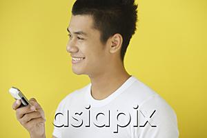 AsiaPix - Man holding mobile phone, looking away