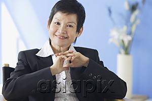 AsiaPix - Business woman smiling at camera, hands clasped