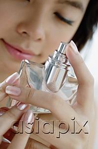 AsiaPix - Young woman with perfume bottle, eyes closed