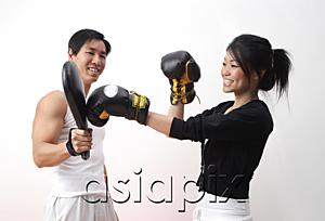 AsiaPix - Young woman with boxing gloves, practicing with trainer