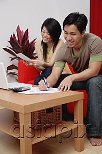 AsiaPix - Couple at home in living room, doing finances