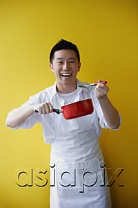 AsiaPix - Man wearing apron and holding saucepan