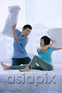 AsiaPix - Couple in bedroom having a pillow fight
