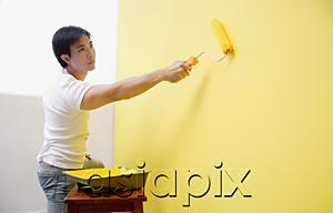 AsiaPix - Man painting wall with yellow paint