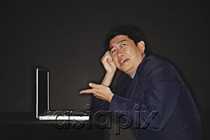 AsiaPix - Businessman pointing at laptop next to him