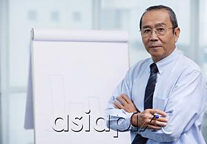 AsiaPix - Businessman standing in front of flip board, portrait