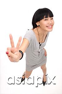 AsiaPix - Young woman smiling up at camera, making peace sign