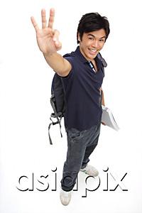 AsiaPix - Young man with books and a backpack, making hand sign