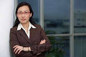 AsiaPix - Businesswoman leaning on wall, arms crossed