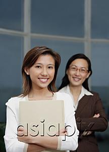 AsiaPix - Businesswomen smiling at camera, focus on the foreground