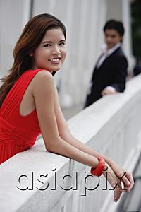 AsiaPix - Woman leaning on bridge railing, smiling at camera, man in the background