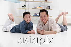 AsiaPix - Father and son lying on floor, smiling at camera, portrait