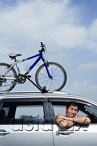 AsiaPix - Man leaning out of car window, bicycle on the roof of car