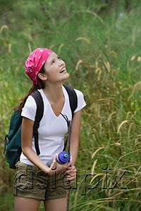 AsiaPix - Woman on hiking trail, looking up, smiling