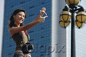 AsiaPix - Woman with camera, framing a shot with her fingers