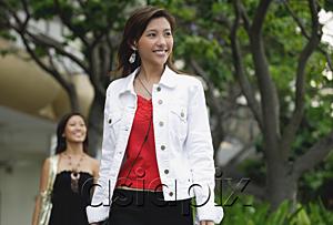 AsiaPix - Woman walking, another woman in the background behind her