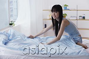 AsiaPix - Young woman making her bed