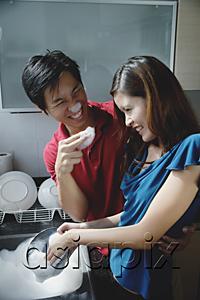 AsiaPix - Couple washing dishes, playing with soap suds