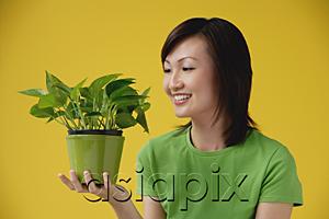AsiaPix - Young Woman looking at plant