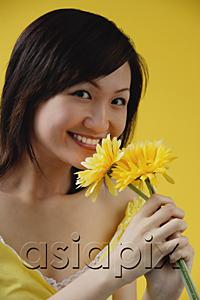 AsiaPix - Young woman smelling flowers