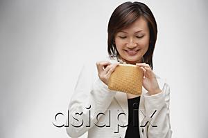 AsiaPix - Young woman looking into purse