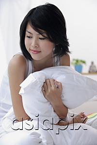 AsiaPix - Young woman hugging pillow, looking away