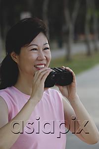 AsiaPix - Mature woman holding binoculars