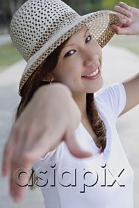 AsiaPix - Young woman wearing hat, pointing finger at camera, selective focus