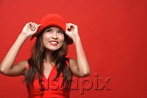 AsiaPix - Woman in red dress with red hat against red background, smiling