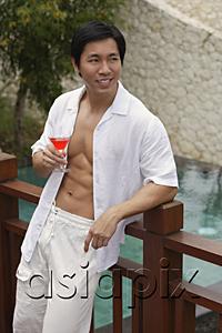 AsiaPix - Man leaning on railing, holding cocktail