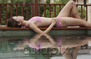 AsiaPix - Woman lying down next to swimming pool