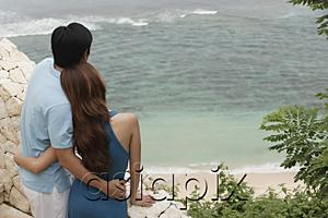 AsiaPix - Couple standing side by side looking out at sea, rear view